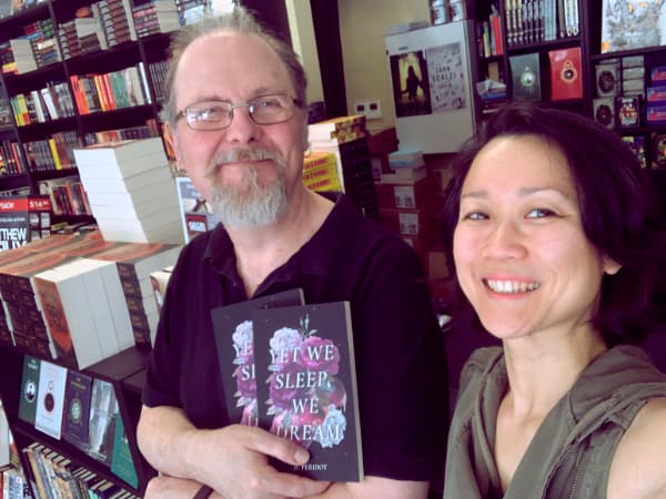 Stefen of Stefen’s Books holding copies of Yet We Sleep, We Dream while we take a selfie